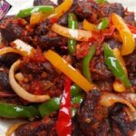 Asun ( Spicy smoked Goatmeat) with cucumber & tomato salad
