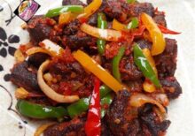 Asun ( Spicy smoked Goatmeat) with cucumber & tomato salad